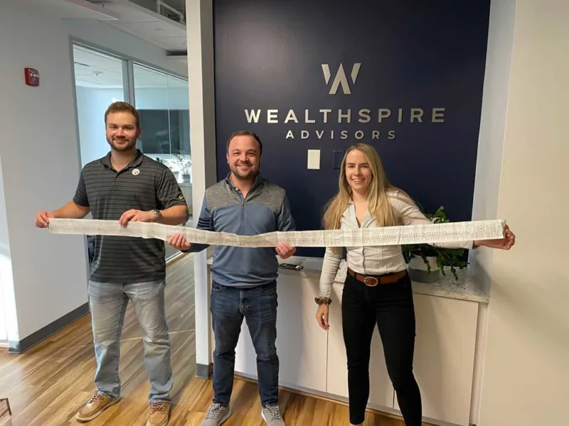 3 coworkers holding a receipt.
